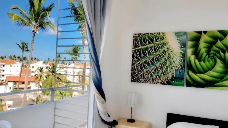Habitación con balcón y vistas a palmeras tropicales en Beach Garden Club Vacation Hotel Punta Cana