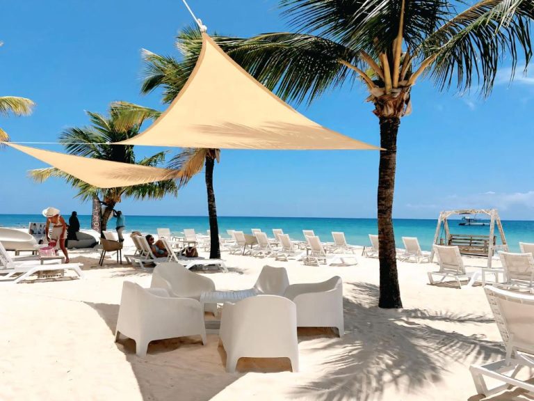 Playa privada con tumbonas blancas y velas de sombra en Beach Garden Club Punta Cana