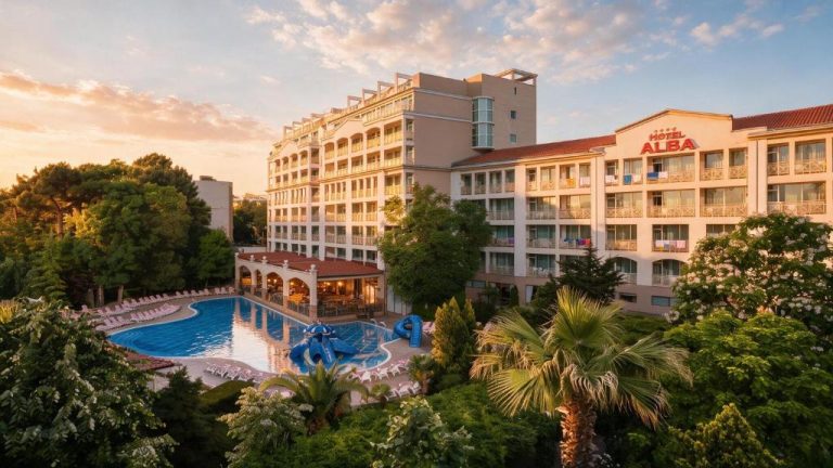 Piscina exterior con toboganes y tumbonas del Hotel Alba All Inclusive al atardecer