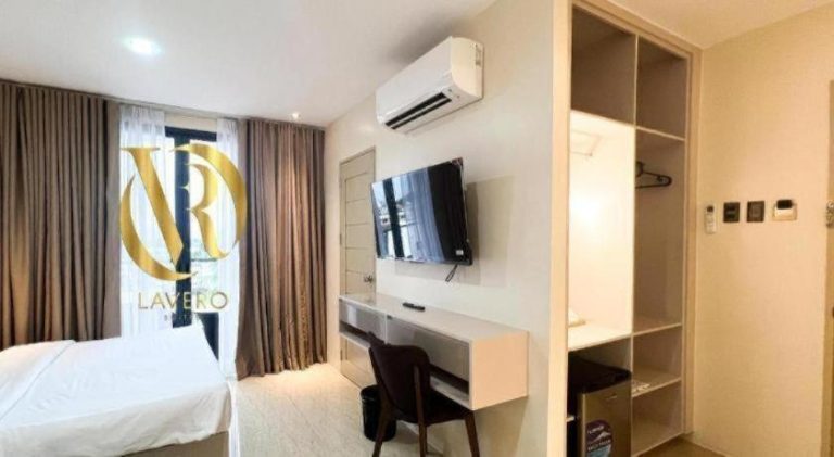 Habitación moderna con escritorio, televisión y aire acondicionado en Lavero Suites