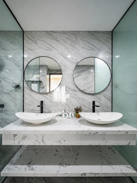 Baño de lujo con doble lavabo sobre encimera de mármol blanco en Welham Boutique Hotel