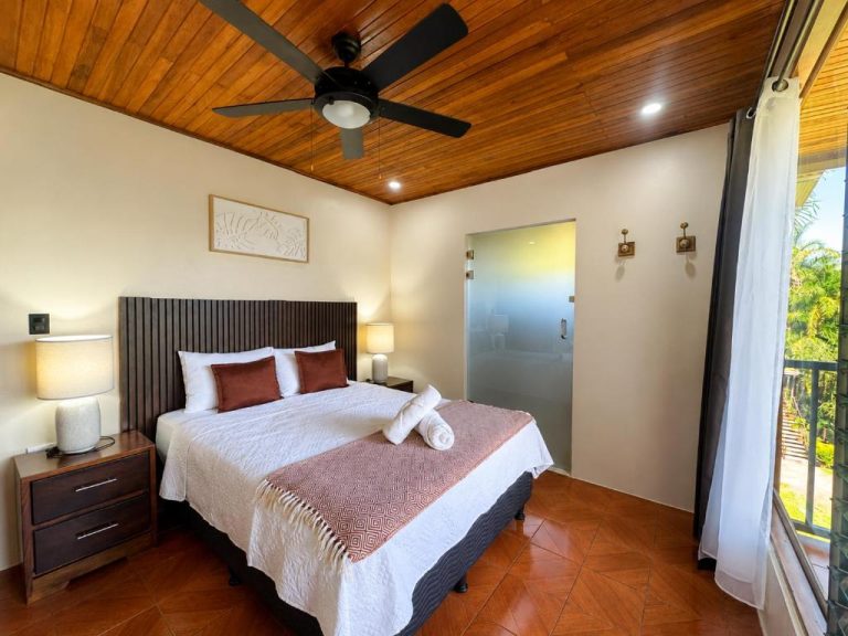 Habitación doble con techo de madera y ventilador en Hotel Villas de la Colina con balcón tropical