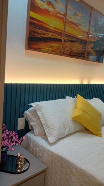Habitación de lujo con cabecero azul, iluminación LED y cuadro de atardecer en Studio Luxuoso frente Mar