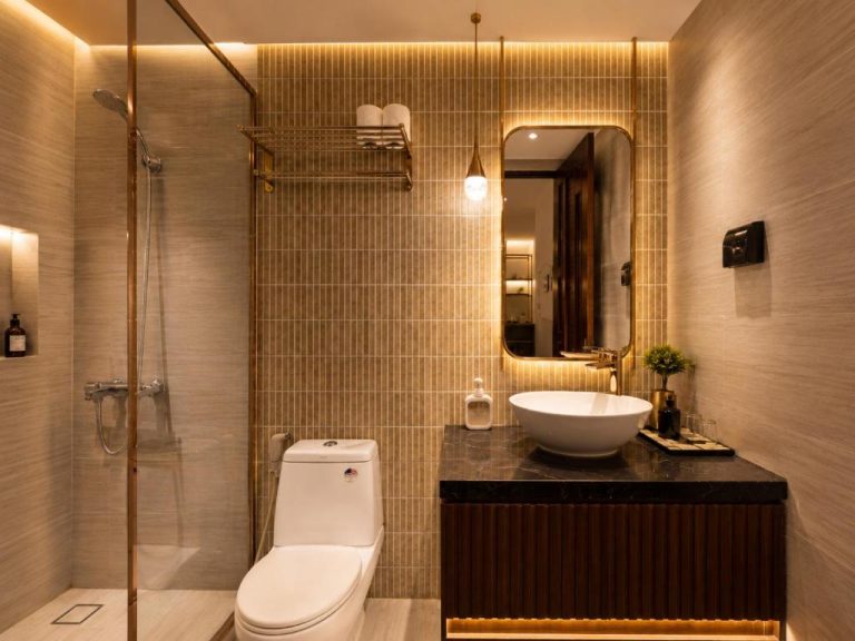 Baño moderno con ducha de cristal y lavabo sobre encimera de mármol en Kas Dilly Ben Thanh Hotel & Spa