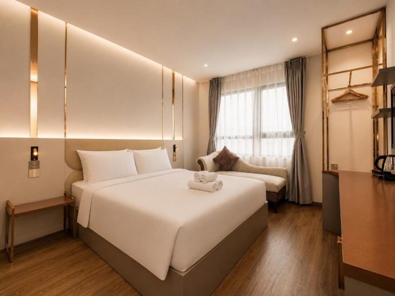 Habitación doble de lujo con cama king size y decoración dorada en Kas Dilly Ben Thanh Hotel & Spa