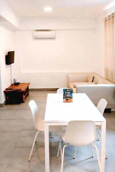 Sala comedor moderna con mesa blanca y sofá en Beach Garden Club Vacation Hotel Punta Cana