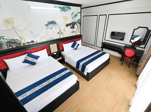 Habitación twin con dos camas y decoración floral en Victory Hotel Saigon South cerca del SECC