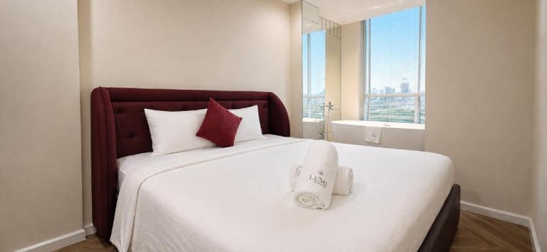 Habitación de lujo con cama doble y baño con bañera independiente en Lumi Residences Central Collection