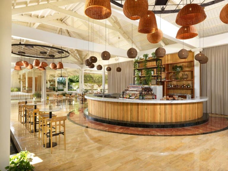 Bar circular de madera con cócteles y lámparas de mimbre en el Meliá Punta Cana Beach Resort