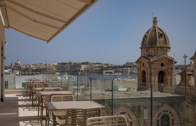 Terraza con mesas y vistas a la bahía y cúpula histórica en Hotel Boeme Sliema Creek, Malta