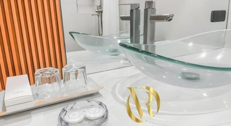 Baño de lujo con lavabo de cristal y amenities en Lavero Suites