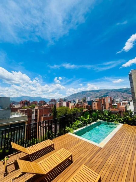 Terraza con piscina y tumbonas del Iconik Hotel con vistas panorámicas a la ciudad de Medellín