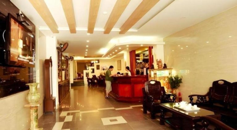 Recepción y lobby interior del Xuan Hung Hotel con mobiliario de madera oscura y decoración clásica