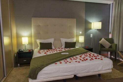 Habitación romántica con pétalos de rosas rojas en la cama del Hotel Santiago