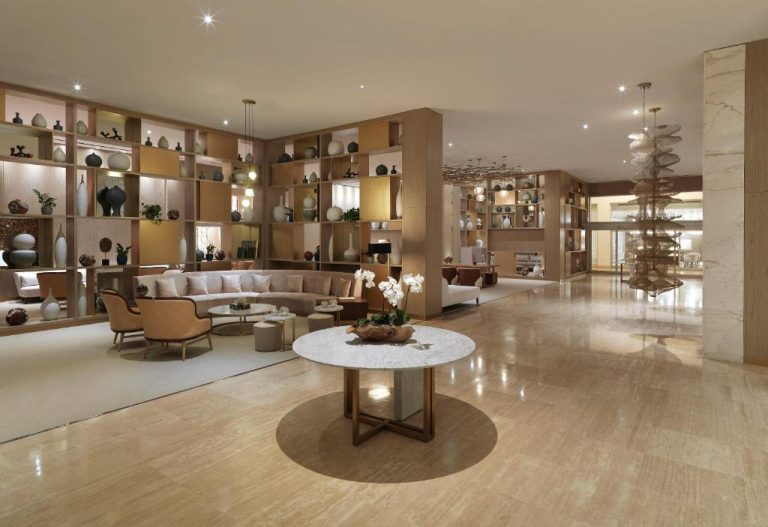 Lujoso lobby del Paradisus by Meliá Grand Cana con sofás, estanterías decorativas y mesa de mármol
