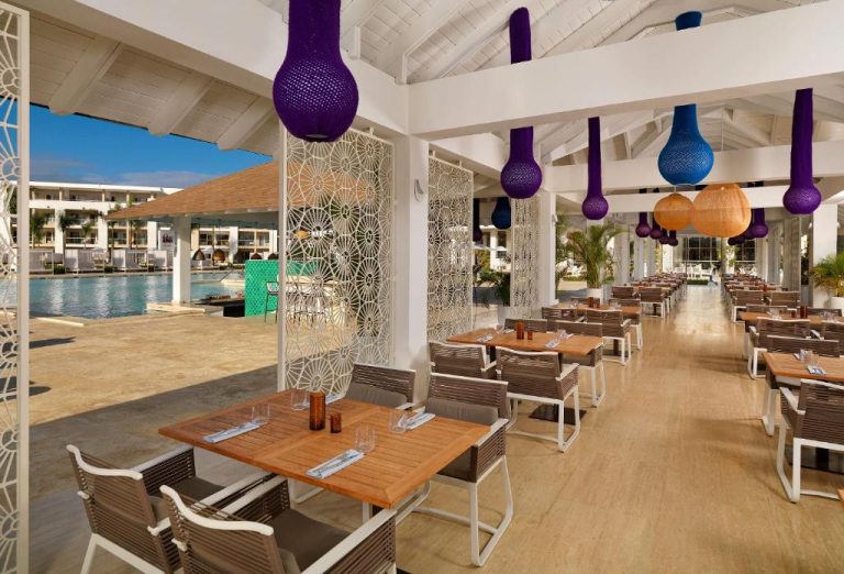 Restaurante al aire libre con vistas a la piscina laguna en el resort Paradisus by Meliá Grand Cana