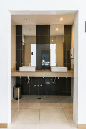 Baño moderno con doble lavabo y gran espejo del Hotel Santiago