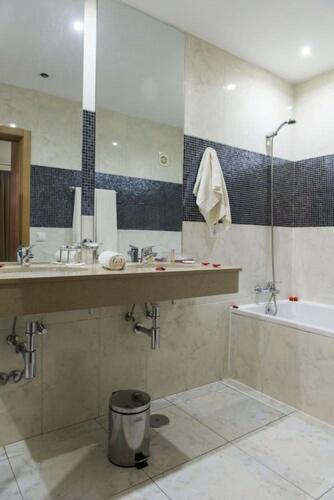 Baño completo con bañera, ducha y espejo amplio en el Hotel Santiago