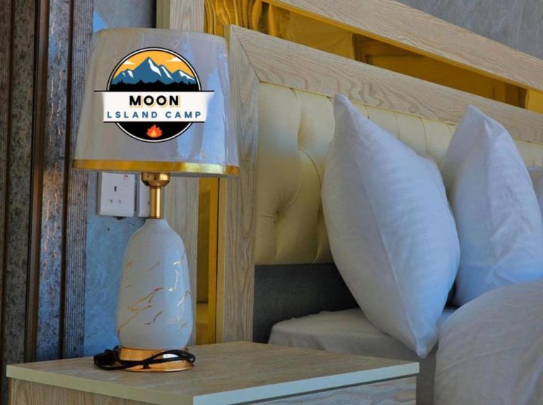 Habitación de lujo con lámpara decorativa dorada y cama con almohadas blancas en Moon Island Luxury Camp