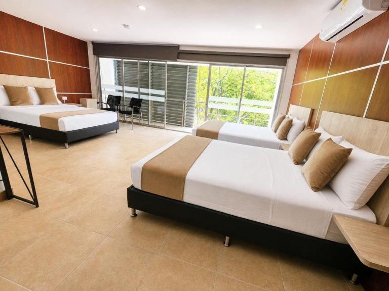 Habitación triple con tres camas y balcón con vistas a jardín en Hotel Med 33