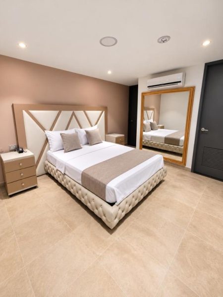 Habitación doble de lujo con cama king size y espejo grande en Hotel Med 33