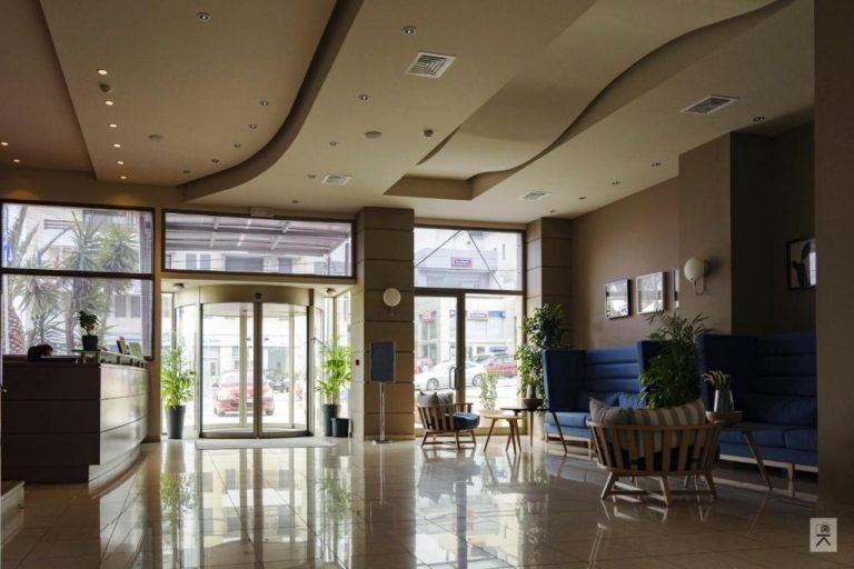 Recepción y lobby moderno del Hotel Avra by Smile Hotels con puerta giratoria y zona de descanso
