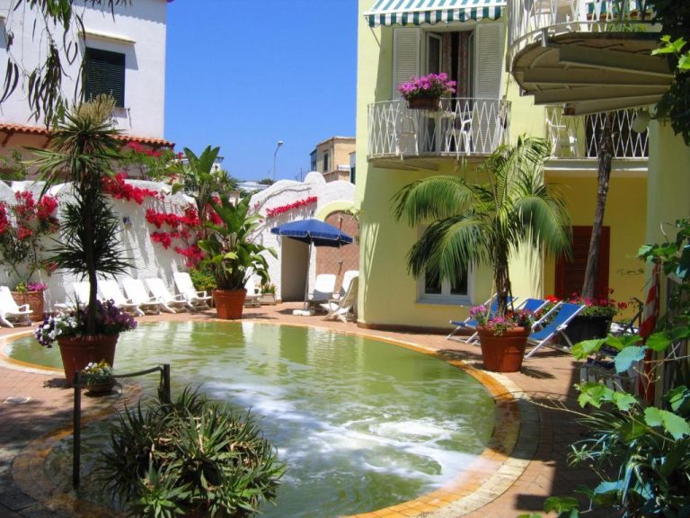 Piscina termal exterior con jardín tropical y tumbonas del Hotel Europa en Ischia